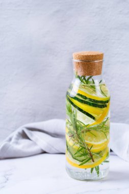 Sağlık hizmeti, fitness, sağlıklı beslenme diyeti konsepti. Taze soğuk limon salatalığı biberiye doldurulmuş su, detoks içeceği, yaz günleri için cam kavanozda limonata..
