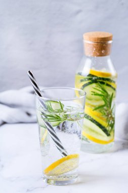 Sağlık hizmeti, fitness, sağlıklı beslenme diyeti konsepti. Taze soğuk limon salatalığı biberiye doldurulmuş su, detoks içeceği, yaz günleri için cam kavanozda limonata..