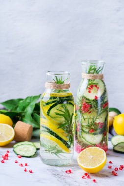 Sağlık hizmeti, fitness, sağlıklı beslenme diyeti konsepti. Taze soğuk limon salatalığı, biberiye, nar suyu, detoks içeceği, yaz günleri için cam kavanozda limonata. Boşluk arkaplanı kopyala