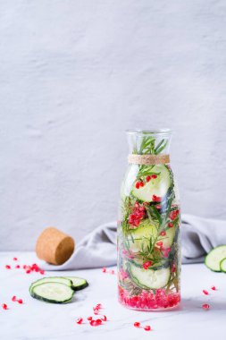 Sağlık hizmeti, fitness, sağlıklı beslenme diyeti konsepti. Taze serin salatalık, nar biberiyesi aşılanmış su, detoks içeceği, yaz günleri için cam kavanozda limonata. Boşluk arkaplanı kopyala