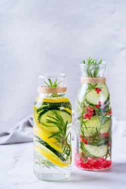 Sağlık hizmeti, fitness, sağlıklı beslenme diyeti konsepti. Taze soğuk limon salatalığı, biberiye, nar suyu, detoks içeceği, yaz günleri için cam kavanozda limonata. Boşluk arkaplanı kopyala