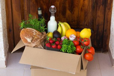 Sıfır israf plastik güvenli ev teslimat servisi. Müşteri kapısının yanındaki geri dönüşümlü pakette bir kutu yiyecek var. İnternetten sipariş, Coronavirus sırasında alışveriş, tecrit, evde kalma, izolasyon.