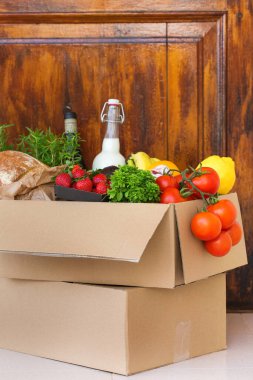Sıfır israf plastik güvenli ev teslimat servisi. Müşteri kapısının yanındaki geri dönüşümlü pakette bir kutu yiyecek var. İnternetten sipariş, Coronavirus sırasında alışveriş, tecrit, evde kalma, izolasyon.