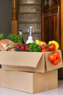 Sıfır israf plastik güvenli ev teslimat servisi. Müşteri kapısının yanındaki geri dönüşümlü pakette bir kutu yiyecek var. İnternetten sipariş, Coronavirus sırasında alışveriş, tecrit, evde kalma, izolasyon.