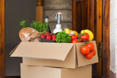 Sıfır israf plastik güvenli ev teslimat servisi. Müşteri kapısının yanındaki geri dönüşümlü pakette bir kutu yiyecek var. İnternetten sipariş, Coronavirus sırasında alışveriş, tecrit, evde kalma, izolasyon.