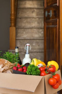 Sıfır israf plastik güvenli ev teslimat servisi. Müşteri kapısının yanındaki geri dönüşümlü pakette bir kutu yiyecek var. İnternetten sipariş, Coronavirus sırasında alışveriş, tecrit, evde kalma, izolasyon.
