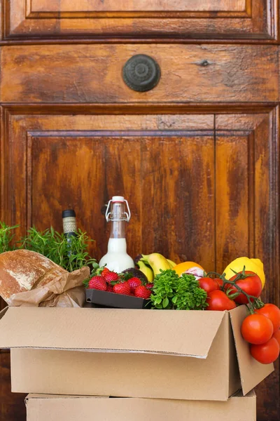 Zero waste no plastic safe home delivery service. Box of food in recyclable package near the customer door. Online internet order, shopping during coronavirus, lockdown, stay at home, isolation