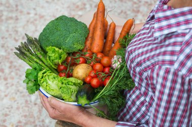 Meyve bahçesinden el ele tutuşan olgun bir yaşlı kadın. Olgun ev yapımı sebzeler çiftçilerin elinde. Organik pazar, bahçıvanlık, biyolojik gıda teslimatı, sıfır atık, çevre dostu konsept.