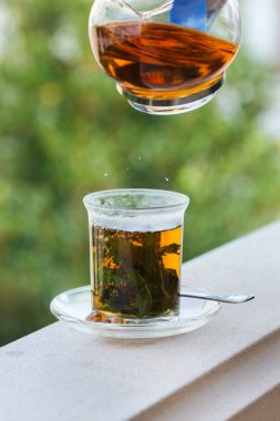 Stres, anksiyete, kronik yorgunluk, depresyon ve rahatlama için iç. Bir bardak kamış şekerli sıcak nane çayı, geleneksel Orta Doğu, Fas, Arap, kırsal içeceği çaydanlıktan dökülüyor.