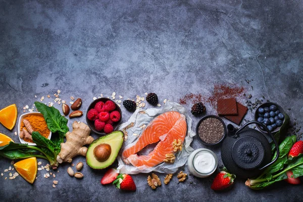 Assortment of healthy feel good food, superfood ingredients for stress, anxiety, chronic fatigue, depression relieving, reducing, for relaxation on a kitchen table. Top view flat lay background