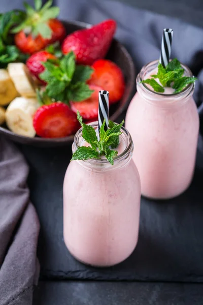 Food and drink, healthy dieting and nutrition, lifestyle, vegan, alkaline, vegetarian concept. Pink smoothie with banana and strawberry on a modern kitchen table. Copy space background