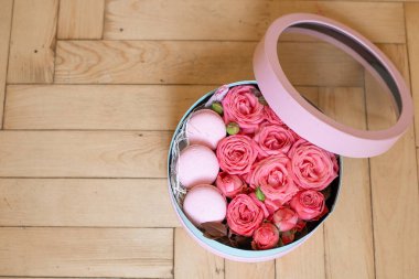 Taze çiçekli mavi kulübe pembe güller ve Fransız şekerlemeleri ve ahşap zeminin üstü. Çiçek aranjmanı, anneler günü için kompozisyon, sevgililer günü, kadınlar günü, doğum günü. Çiçekçiyi kapat.