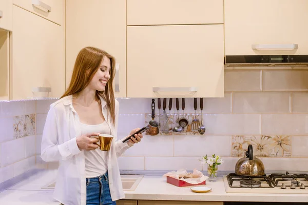 Feliz Mulher Sorridente Segurando Telefone Celular Xícara Ouro Com Café — Fotografia de Stock