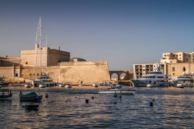 Deniz manzaralı Malta. Malta 'nın başkenti Valletta' nın geleneksel evleri ve duvarları açık mavi gökyüzüyle gün doğumundan önceki bir yaz sabahı. Üç Şehir Körfezi.