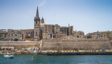 Deniz manzaralı Malta. Malta 'nın başkenti Valletta' nın geleneksel evleri ve duvarları açık mavi gökyüzüyle gün doğumundan önceki bir yaz sabahı. Üç Şehir Körfezi.