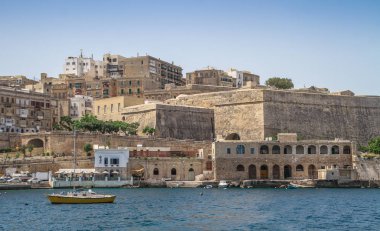 Deniz manzaralı Malta. Malta 'nın başkenti Valletta' nın geleneksel evleri ve duvarları açık mavi gökyüzüyle gün doğumundan önceki bir yaz sabahı. Üç Şehir Körfezi.
