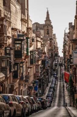 Valletta, Malta şehir manzarası. Valletta 'daki Dar Sokak - Malta' nın başkenti. Geleneksel Malta mimarisi. La Valetta 'nın eski tarihi parçası. Dışarıda insanlar ve dar sokaklar, Malta.