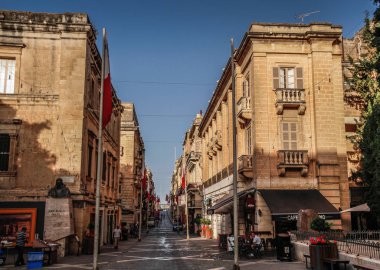 Valletta, Malta şehir manzarası. Valletta 'daki Dar Sokak - Malta' nın başkenti. Geleneksel Malta mimarisi. La Valetta 'nın eski tarihi parçası. Dışarıda insanlar ve dar sokaklar, Malta.