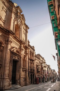 Valletta, Malta şehir manzarası. Valletta 'daki Dar Sokak - Malta' nın başkenti. Geleneksel Malta mimarisi. La Valetta 'nın eski tarihi parçası. Dışarıda insanlar ve dar sokaklar, Malta.
