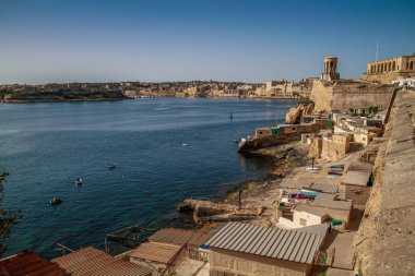 Valletta, Malta şehir manzarası. Valletta 'daki Dar Sokak - Malta' nın başkenti. Geleneksel Malta mimarisi. La Valetta 'nın eski tarihi parçası. Dışarıda insanlar ve dar sokaklar, Malta.