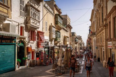 Valletta, Malta şehir manzarası. Valletta 'daki Dar Sokak - Malta' nın başkenti. Geleneksel Malta mimarisi. La Valetta 'nın eski tarihi parçası. Dışarıda insanlar ve dar sokaklar, Malta.