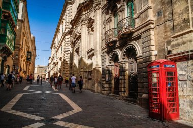 Valletta, Malta şehir manzarası. Valletta 'daki Dar Sokak - Malta' nın başkenti. Geleneksel Malta mimarisi. La Valetta 'nın eski tarihi parçası. Dışarıda insanlar ve dar sokaklar, Malta.