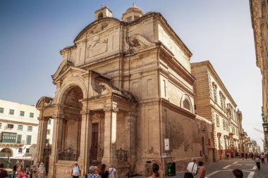 Valletta, Malta şehir manzarası. Valletta 'daki Dar Sokak - Malta' nın başkenti. Geleneksel Malta mimarisi. La Valetta 'nın eski tarihi parçası. Dışarıda insanlar ve dar sokaklar, Malta.