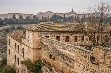 İspanya 'nın tarihi Toledo şehrinin manzarası. Unesco Dünya Mirası Bölgesi. Ortaçağ mimari tarzı olan Alcazar ve Alcantara Köprüsü (Puente de Alcantara) ile aynı caddeye çıktı. Toledo.