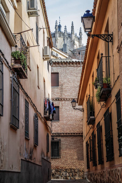View of the historic city of Toledo, Spain. UNESCO world heritage site. Medieval cobbled and stepped street with moorish architecture style, Alcazar and Alcantara Bridge ( Puente de Alcantara). Toledo