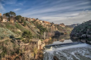 İspanya 'nın tarihi Toledo şehrinin manzarası. Unesco Dünya Mirası Bölgesi. Ortaçağ mimari tarzı olan Alcazar ve Alcantara Köprüsü (Puente de Alcantara) ile aynı caddeye çıktı. Toledo.
