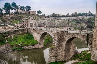 İspanya 'nın tarihi Toledo şehrinin manzarası. Unesco Dünya Mirası Bölgesi. Ortaçağ mimari tarzı olan Alcazar ve Alcantara Köprüsü (Puente de Alcantara) ile aynı caddeye çıktı. Toledo.