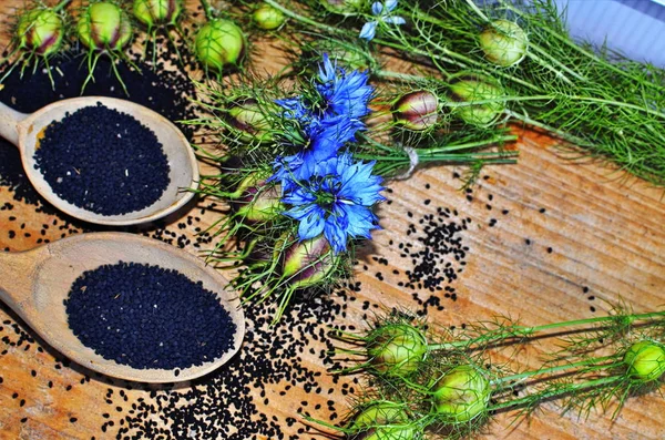 Kara kimyon (nigella sativa veya kalonji) tohumları tahtadan arka planda kalp şeklindeki kase içinde