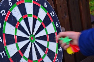 Hedef merkezde dart dartıyla dart oyunu. Renkli oklar hedefi vuruyor.