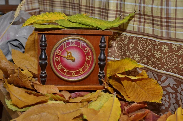 Daylight saving time. Retro styled photo. Vintage black alarm clock on autumn leaves. Time change abstract photo. Daylight saving time (DST)