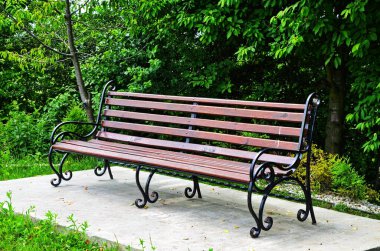 Yazın yemyeşil parklarda ahşap bir bank