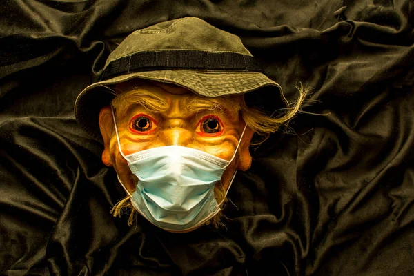A theatrical mask in a protective medical mask. Coronavirus covid - 19.