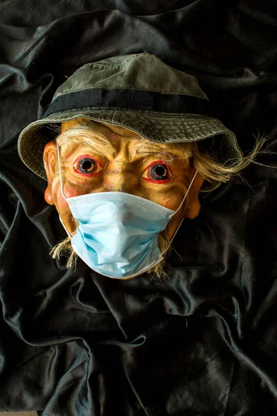 A theatrical mask in a protective medical mask. Coronavirus covid - 19.
