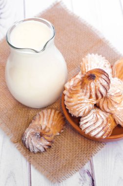 Süt ve bisküvi ahşap bir masa üzerinde plaka