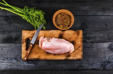 Taze çiğ tavuk fileto kesme tahtası bir bıçakla, baharatlar