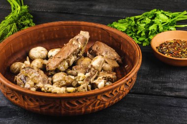 Komposto petrol ve parlak bir tabak, baharat, maydanoz, dereotu soğanlı dana kaburga. siyah ahşap arka plan üzerinde. Fried mantar ve şeffaf levha zeytin.