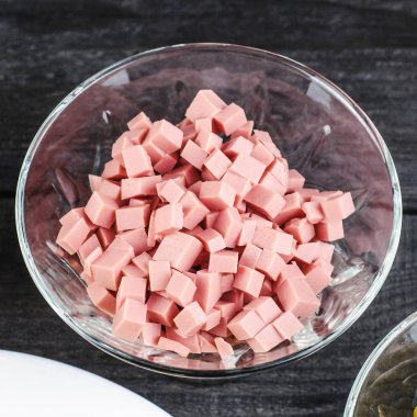 Siyah ahşap backgro şeffaf bir tabağa içinde ezilmiş sosis