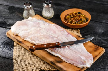 Pangasius fileto baharat ve bıçak siyah ahşap zemin ile ahşap kesme tahtası.
