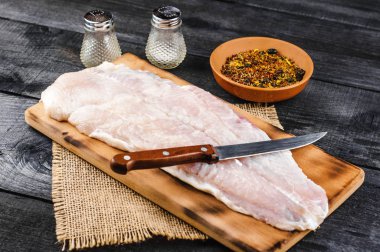 Pangasius fileto baharat ve bıçak siyah ahşap zemin ile ahşap kesme tahtası.