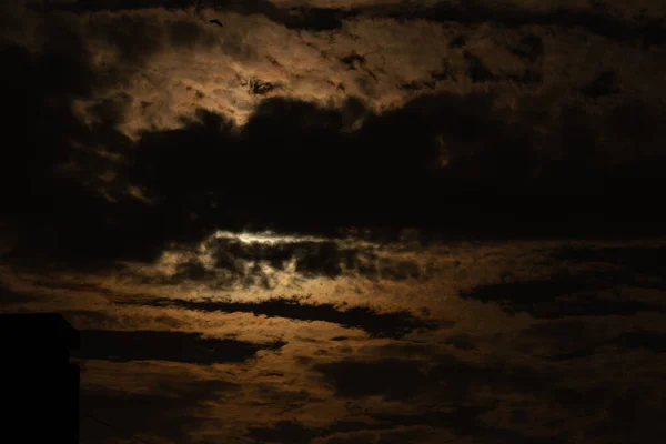 日没時には雲が2つに分かれ オレンジ色と金色の太陽の光があります — ストック写真