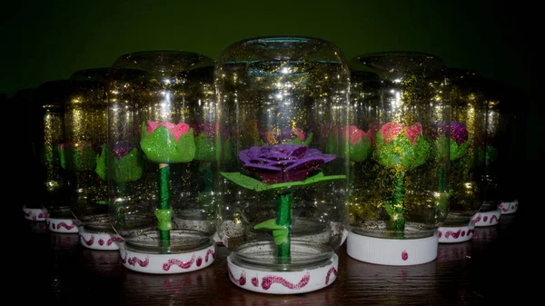 Sentetik el yapımı çiçekler ve bir şişe su ile girmiştir