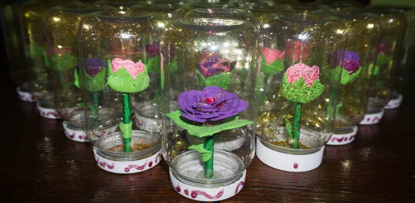 Sentetik el yapımı çiçekler ve bir şişe su ile girmiştir