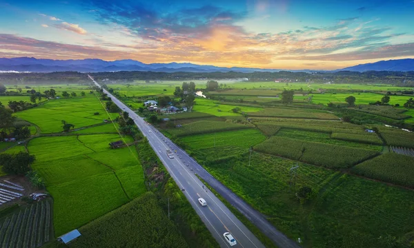 Top view of green field for background, aerial beautiful landscape photos view from above ,and road cars moving in the green fields in countryside.