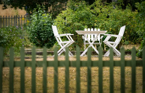 Kerti szék és asztal, kerítésen mögött — Stock Fotó