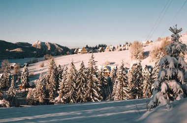 Güneşli kış sabahı Polonya Tatra Dağları. Taze kar kalın tabakası dağ tepe Köyü ahşap evler ve ağaçları ile kaplı. Zakopane Polonya