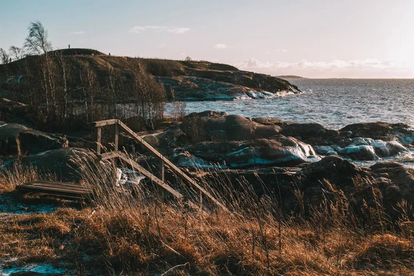 Escaleras de madera junto a la costa rocosa del mar. Helsinki - Finlandia — Foto de Stock